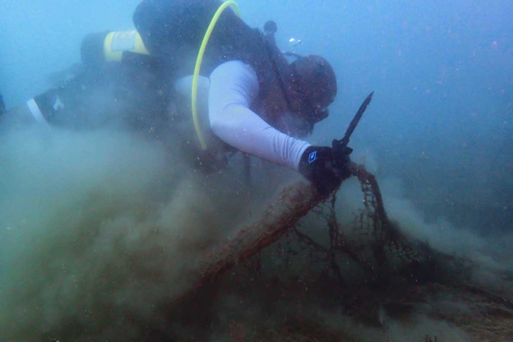 Diver removing ghost gear from the sea. Image.