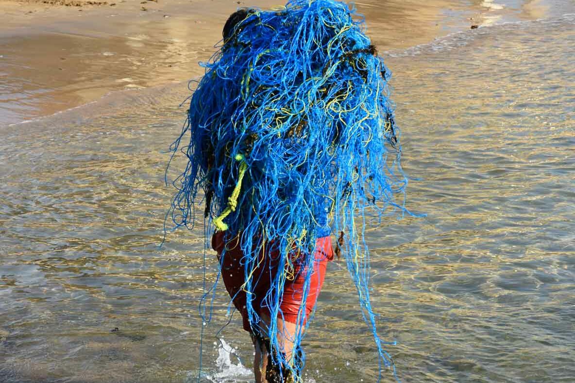 ORP staff carrying ghost net out of the ocean