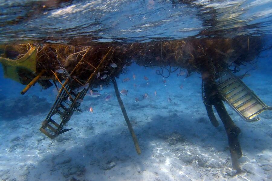 Monster ghost net with a deck chair, stairs and a tree trunk entangled, North Male Atoll, Maldives