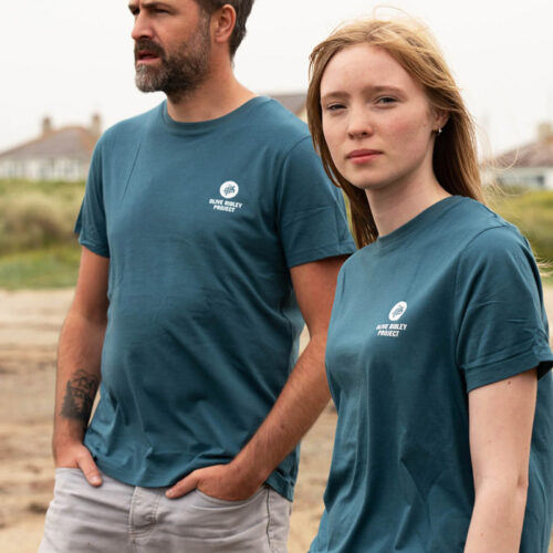 Male and female models wearing a sustainable T-shirt made from organic cotton and seaweed blend, featuring a sea turtle design on the back. Proceeds from sales support sea turtle conservation. Image.