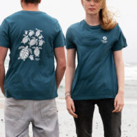 Male and female models wearing a sustainable T-shirt made from organic cotton and seaweed blend, featuring a sea turtle design on the back and Olive Ridley Project's ;ogo on the front. Proceeds from sales support sea turtle conservation. Image.