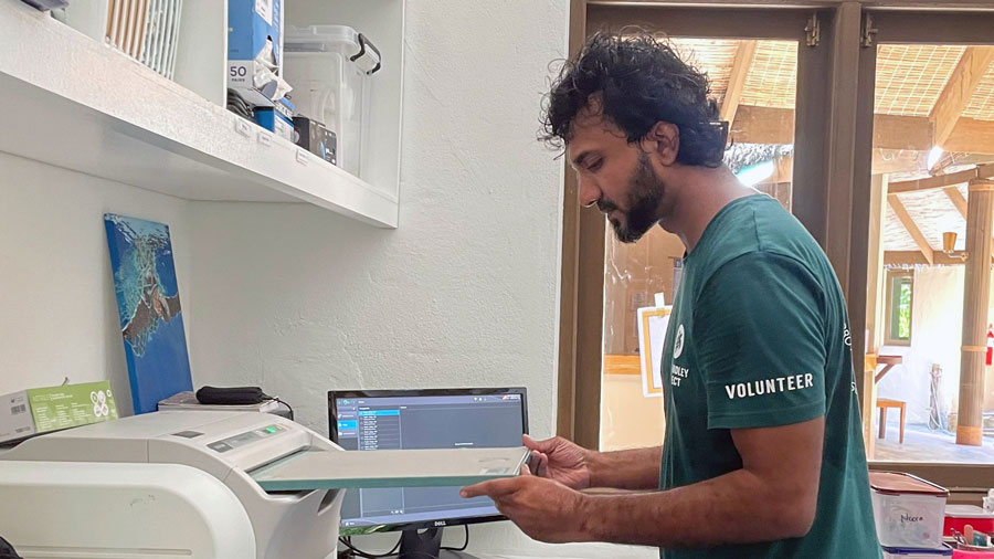 Veterinary-trainee-Dr-Misfah_Xray-plate-into-the-scanner Image of veterinary trainee Dr Misfah placing an X-ray plate in the scanner at the MTRC.
